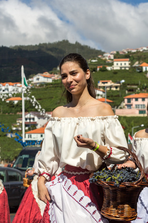 ESTREITO DE CAMARA DE LOBOS, PORTUGAL - SEPTEMBER 10, 2016: Woman wearing in traditional costume at Madeira Wine Festival in Estreito de Camara de Lobos, Madeira, Portugal. The Madeira Wine Festival honors the grape harvest with a celebration of traditionのeditorial素材
