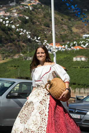 ESTREITO DE CAMARA DE LOBOS, PORTUGAL - SEPTEMBER 10, 2016: Woman wearing in traditional costume at Madeira Wine Festival in Estreito de Camara de Lobos, Madeira, Portugal. The Madeira Wine Festival honors the grape harvest with a celebration of traditionのeditorial素材
