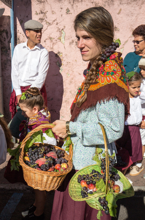 ESTREITO DE CAMARA DE LOBOS, PORTUGAL - SEPTEMBER 10, 2016: People wearing in traditional costumes at Madeira Wine Festival in Estreito de Camara de Lobos, Madeira, Portugal. The Madeira Wine Festival honors the grape harvest with a celebration of traditiのeditorial素材