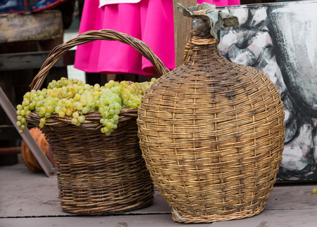 old barrels and tools for wine production and  baskets with grapes