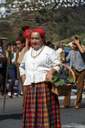 ESTREITO DE CAMARA DE LOBOS, PORTUGAL - SEPTEMBER 10, 2016: People wearing in traditional costumes at Madeira Wine Festival in Estreito de Camara de Lobos, Madeira, Portugal. The Madeira Wine Festival honors the grape harvest with a celebration of traditiのeditorial素材