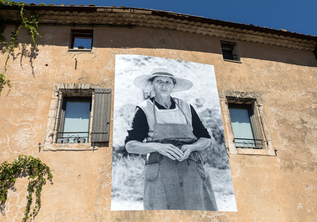 GORDES, FRANCE - JUNE 25, 2017: A typical old stone house with a billboard depicting the scenes of old-fashioned life in Gordes village, Vaucluse, Provence, Franceのeditorial素材