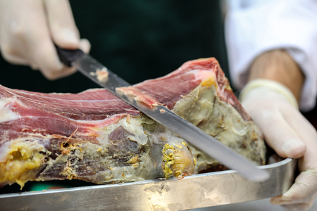 Cutting slices of cured iberian hamの写真素材