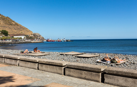 MACHICO, MADEIRA, PORTUGAL - SEPTEMBER 11, 2016: People are resting on a sunny day at the beach in Machico. Madeira Island, Portugalのeditorial素材