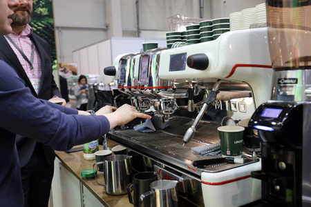 Cracow, Poland - November 16, 2017:  Barista making coffee at coffee machine at Gastrofood - Trade Fair for Food and Drinks for Catering in Cracow. Polandのeditorial素材