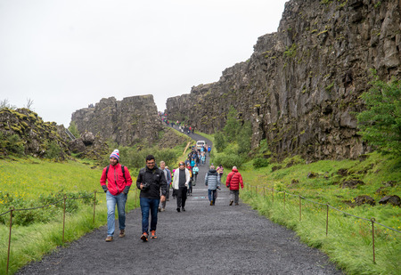 Thingvellir, Iceland - July 19, 2017: Tourists walk through the Almannagja fault line in the mid-atlantic ridge north american plate in Thingvellir National Park. Iceland のeditorial素材