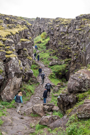 Thingvellir, Iceland - July 19, 2017: Tourists walk through the Almannagja fault line in the mid-atlantic ridge north american plate in Thingvellir National Park. Iceland のeditorial素材
