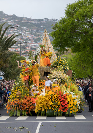 Funchal, Madeira, Portugal - April 22, 2018 : A group of people in colorful costumes on the floral float at Madeira Flower Festival Parade in Funchal on the Island of Madeira. Portugal.のeditorial素材