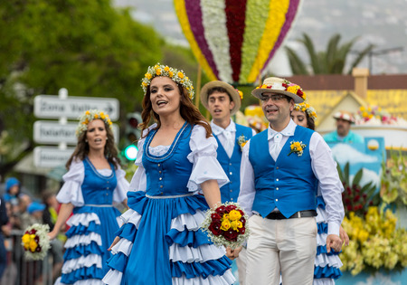 Funchal; Madeira; Portugal - April 22; 2018: A group of people in colorful costumes are dancing at Madeira Flower Festival Parade in Funchal on the Island of Madeira. Portugal.のeditorial素材