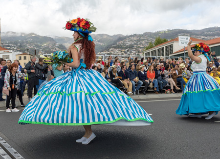 Funchal; Madeira; Portugal - April 22; 2018: A group of women in colorful costumes are dancing at Madeira Flower Festival Parade in Funchal on the Island of Madeira. Portugal.のeditorial素材