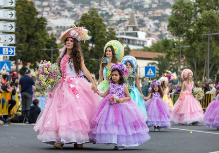 Funchal; Madeira; Portugal - April 22; 2018: A group of people in colorful costumes are dancing at Madeira Flower Festival Parade in Funchal on the Island of Madeira. Portugal.のeditorial素材