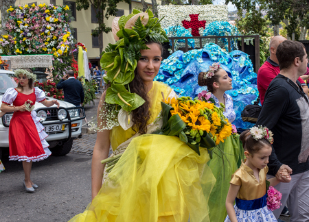 Funchal; Madeira; Portugal - April 22; 2018: The last moments before the parade, Beautiful woman in a yellow dress with a bouquet in the hands at the Madeira Flower Festival , Funchal, Madeira, Portugalのeditorial素材