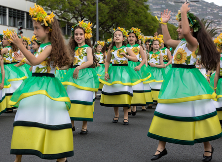 Funchal; Madeira; Portugal - April 22; 2018: A group of girls in colorful dresses are dancing at Madeira Flower Festival Parade in Funchal on the Island of Madeira. Portugal.のeditorial素材