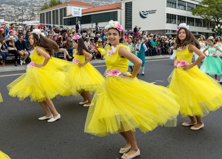 Funchal; Madeira; Portugal - April 22; 2018: A group of girls in colorful costumes are dancing at Madeira Flower Festival Parade in Funchal on the Island of Madeira. Portugal.のeditorial素材