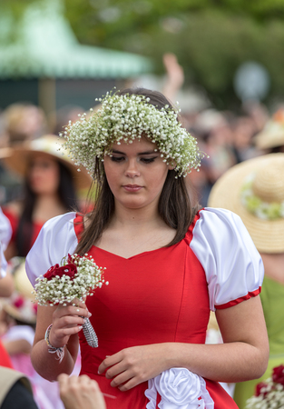 Funchal; Madeira; Portugal - April 22; 2018: The last moments before the parade, Beautiful woman in a red dress with a bouquet in the hands at the Madeira Flower Festival , Funchal, Madeira, Portugalのeditorial素材