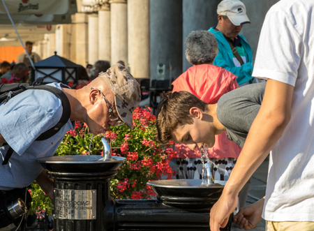 Cracow, Poland - July 5, 2018: Woman is refreshing at fountain in sweltering hot days on Main Square in Cracowのeditorial素材