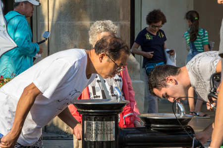 Cracow, Poland - July 5, 2018: Woman is refreshing at fountain in sweltering hot days on Main Square in Cracowのeditorial素材