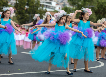 Funchal; Madeira; Portugal - April 22; 2018: A group of children in colorful costumes are dancing at Madeira Flower Festival Parade in Funchal on the Island of Madeira. Portugal.のeditorial素材