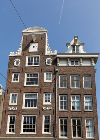 Traditional historic Dutch gable houses beside canal in Amsterdam The Netherlandsの写真素材