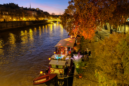 Paris, France - November, 2017: Paris in Autumn. The sun lights the river Seine, the turned yellow trees ashore and beautiful houses which make an architectural complex of the embankmentのeditorial素材
