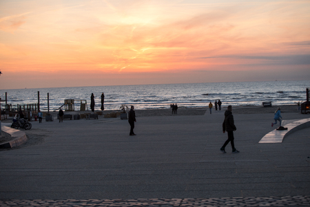 Katwijk, Netherlands - April 23, 2017: People are walking along the beach in Katwijk at sunset. Netherlandsのeditorial素材