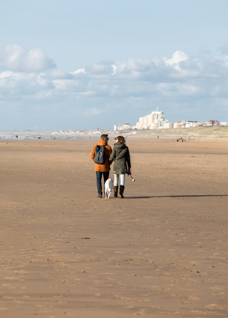 Katwijk, Netherlands - April 23, 2017: A woman and a man are walking on a sunny day along the beach in Katwijk. Netherlandsのeditorial素材