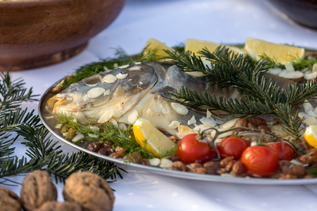 carp with lemon, almonds and cherry tomatoes on the plateの写真素材