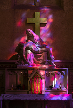 St Emilion, France - September 8, 2018: Pieta in Hues of Purple and red - symbolic reference to the...