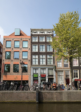 Amsterdam, Netherlands - April 20, 2017: Canal  scene with a bicycles, sidewalk cafe and traditional Dutch houses in Amsterdam. Netherlandsのeditorial素材