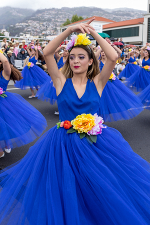 Funchal; Madeira; Portugal - April 22; 2018: A group of girls in colorful costumes are dancing at Madeira Flower Festival Parade in Funchal on the Island of Madeira. Portugal.のeditorial素材