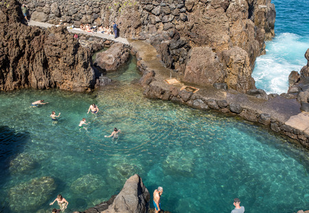 Porto Moniz, Madeira, Portugal - April 18, 2018: Natural rock pool of Porto Moniz on Madeira Island. Portugal.  It is a public bath with water from the Atlantic Ocean.のeditorial素材