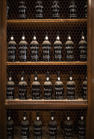 Funchal, Madeira, Portugal - April 23, 2018: Museum - repository of expensive vintage wine Madera. Long rows of shelves made of bottles of wine. funchal, Madera. Portugalのeditorial素材