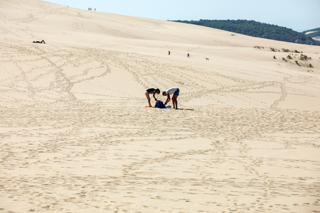 Dune of Pilat, France - September 10,2018: A couple of people are resting on the Dune of Pilat, the tallest sand dune in Europe. La Teste-de-Buch, Arcachon Bay, Aquitaine, Franceのeditorial素材