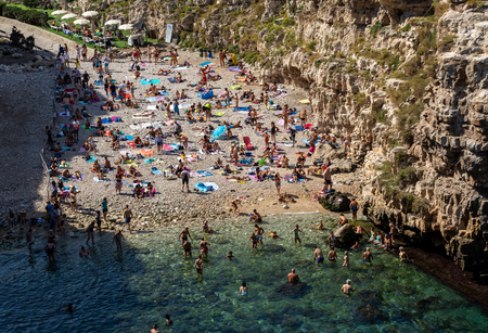 Polignano a Mare, Italy - September 17, 2019: People relax and swimming on lovely beach Lama Monachile in Polignano a Mare, Adriatic Sea, Apulia, Bari province, Italy,のeditorial素材