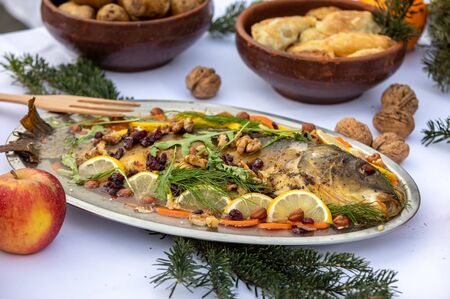 carp with lemon, walnuts and raisins on the plateの写真素材