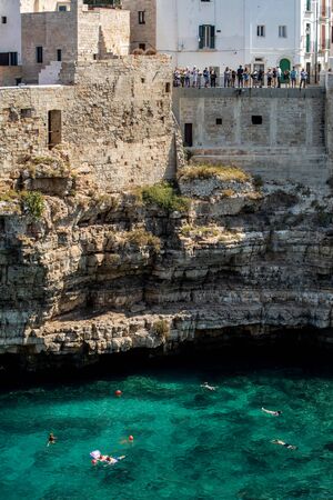 Polignano, Italy - September 17, 2019: People relax and swimming on lovely beach Lama Monachile in Polignano a Mare, Adriatic Sea, Apulia, Bari province, Italy,のeditorial素材