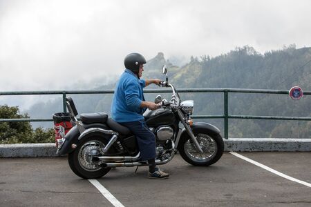 Boca da Encumeada, Madeira, Portugal - April 18, 2018: Motorcyclist in the parking lot on the Boca de Ecumenada pass. Madeira island. Portugalのeditorial素材