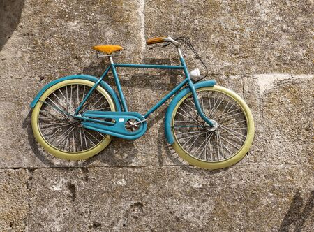 old blue bicycle hanging on the wall in  Les Baux de Provence. Franceの写真素材