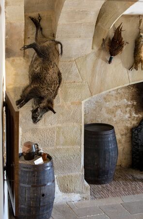 Castelnaud, Dordogne, France - September 7, 2018: Hunting trophies hanging on the kitchen wall in Castelnaud Castle, medieval fortress at Castelnaud-la-Chapelle, Dordogne, Aquitaine, Franceのeditorial素材