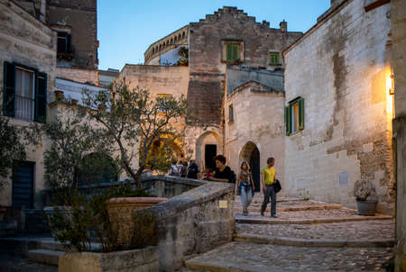 Matera, Italy - September 15, 2019: Tourists during a walk on Cobblestone street in the Sassi di Matera a historic district in the city of Matera. Basilicata. Italyのeditorial素材