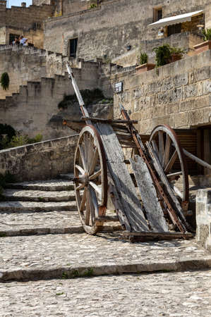 Matera, Italy - September 15, 2019: Typical cobbled stairs and old wooden cart in a side street...