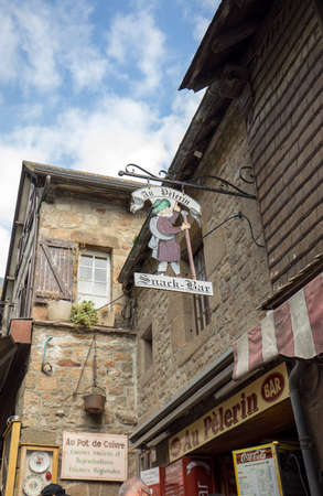 Le Mont-Saint-Michel, France - September 13, 2018: Artistically stylized advertising of restaurants and shops on the Grand Rue, the main street in Mont Saint Michele. Normandy, Franceのeditorial素材