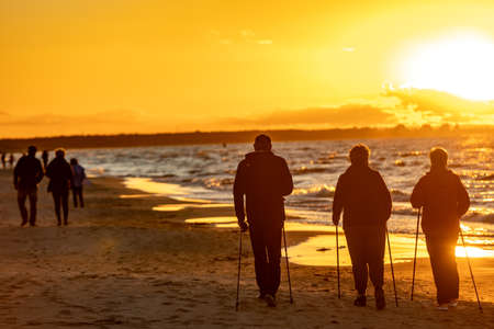 Stegna, Poland - September 7, 2020: Active and healthy lifestyle. Nordic walking on a sandy beach sea shoreの写真素材