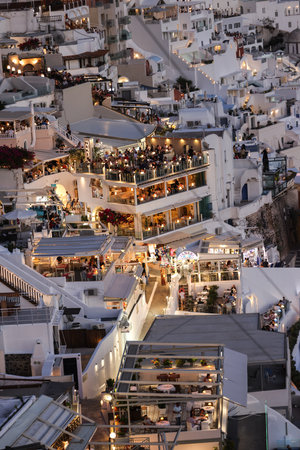 Fira, Santorini, Greece - June 27, 2021: Illuminated balcony decks and patios with restaurants of Fira town on Santorini island. Cyclades, Greeceのeditorial素材