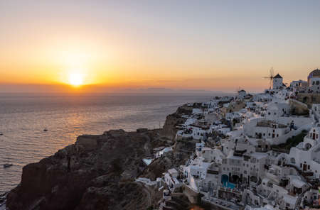 Oia, Santorini, Greece - June 28, 2021: Whitewashed houses and windmills in Oia in warm rays of sunset on Santorini island. Greeceのeditorial素材