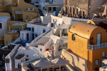 Oia, Santorini, Greece - June 28, 2021: Whitewashed houses and windmills in Oia in warm rays of sunset on Santorini island. Greeceのeditorial素材