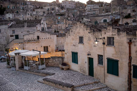 Matera, Italy - September 20, 2019: Evening view of the city of Matera, Italy, with the colorful lights highlighting patios of sidewalk cafes in the Sassi di Matera a historic district in the city of Matera. Basilicata. Italyのeditorial素材