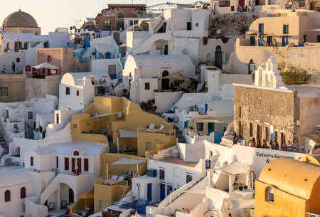 Oia, Santorini, Greece - June 28, 2021: Whitewashed houses in Oia in warm rays of sunset on Santorini island. Greeceのeditorial素材