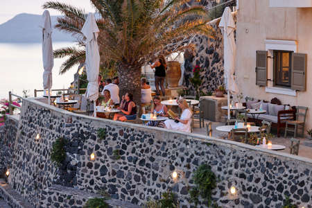 Fira, Santorini, Greece - June 27, 2021: Terrace by the restaurant with a picturesque view of the sunset in Fira. Santorini, Greeceのeditorial素材