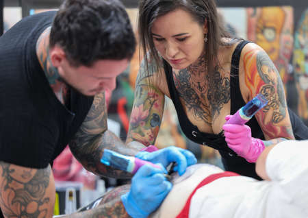 Krakow, Poland - June 11, 2022: 15th Tattoofest in Cracow. One of the most prestigious tattoo festivals. Tattoo artist at work. The process of tattooing.のeditorial素材